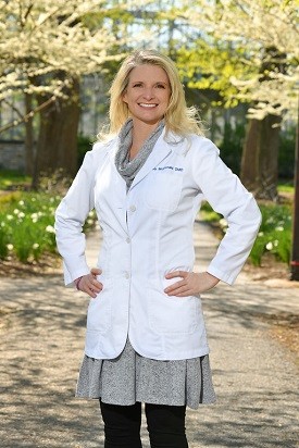 Dr. Lisa McDonald, DMD, standing outside in a scenic park, showcasing her commitment to high-quality and compassionate dental care.